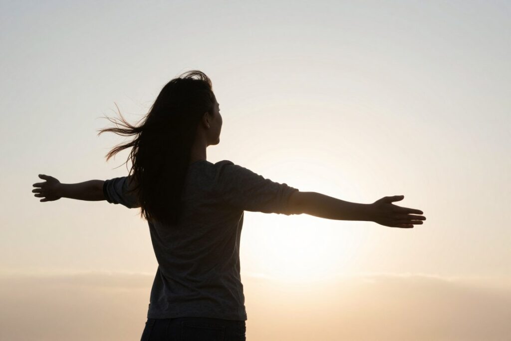 Person standing at new beginning looking toward horizon with hope